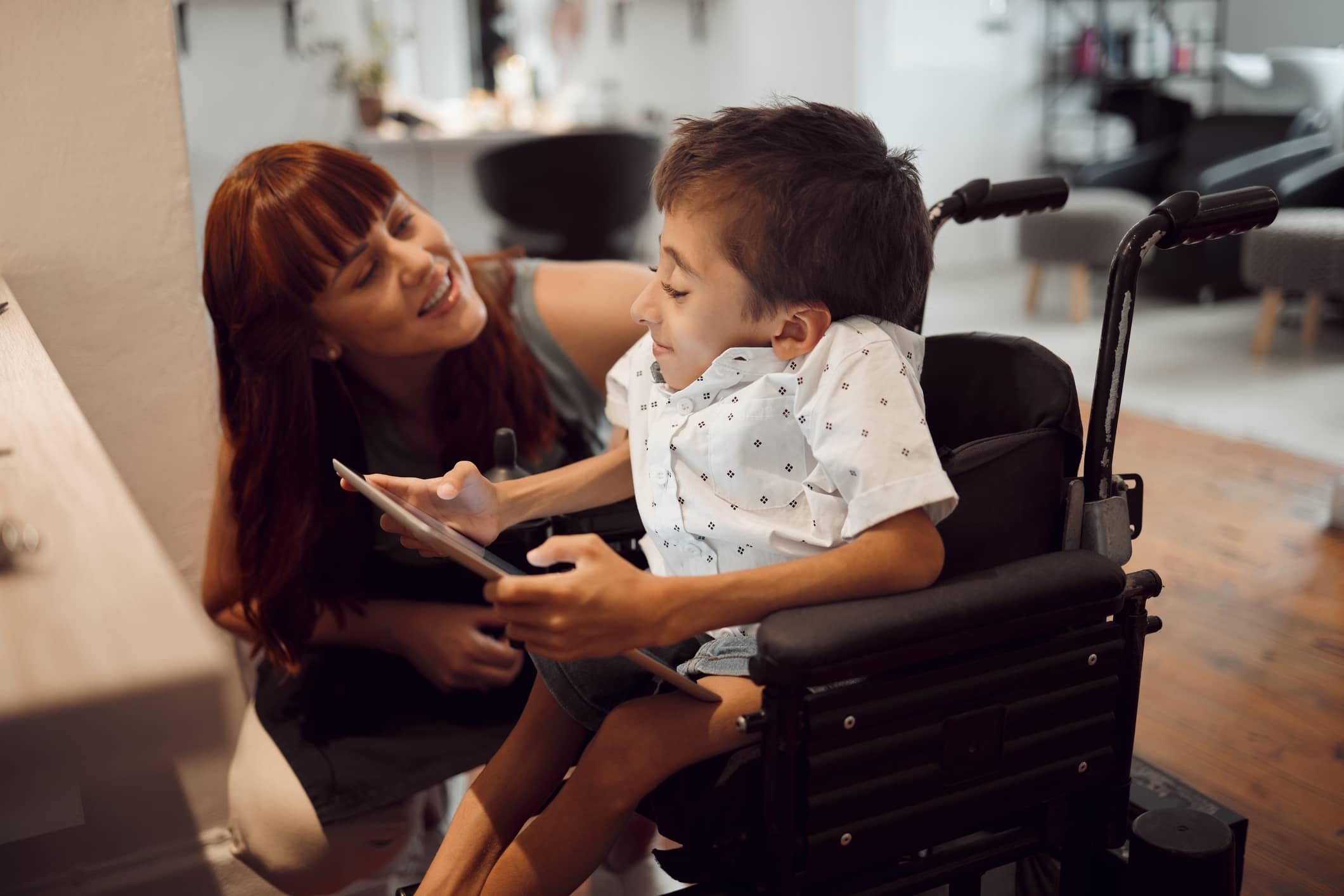 Woman smiling at child in chair