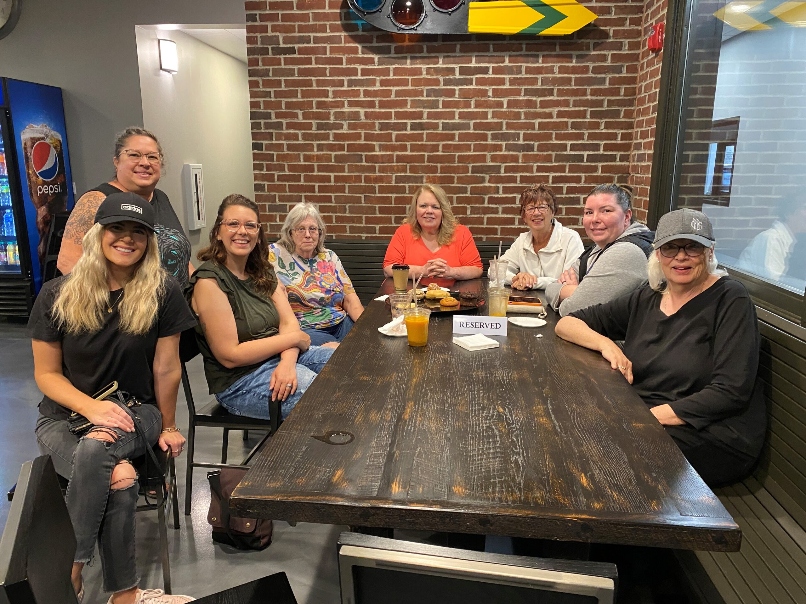 A group of moms sitting around a table looking at the camera and smiling.