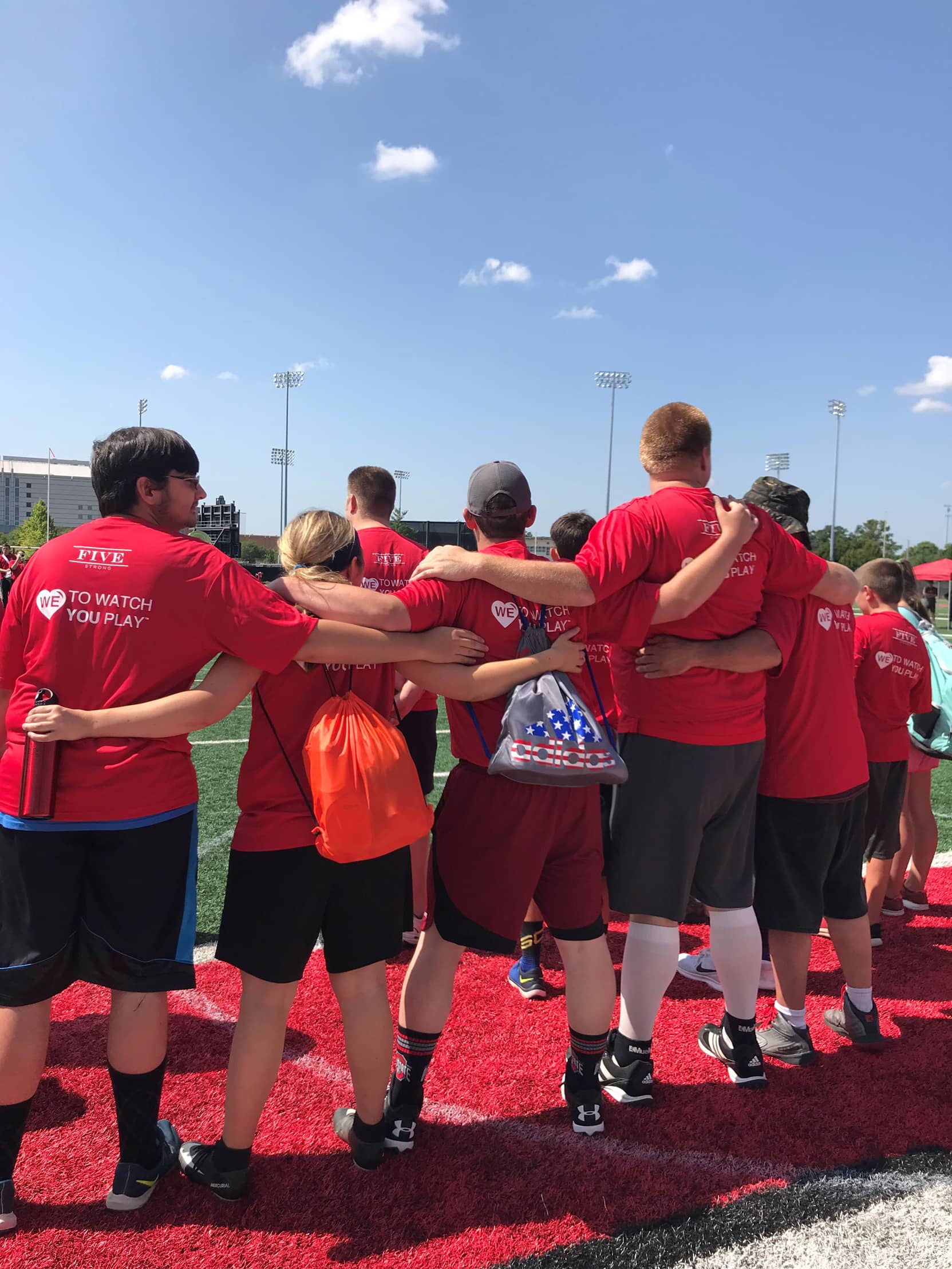 A group of 5 Special Olympics athletes hugging